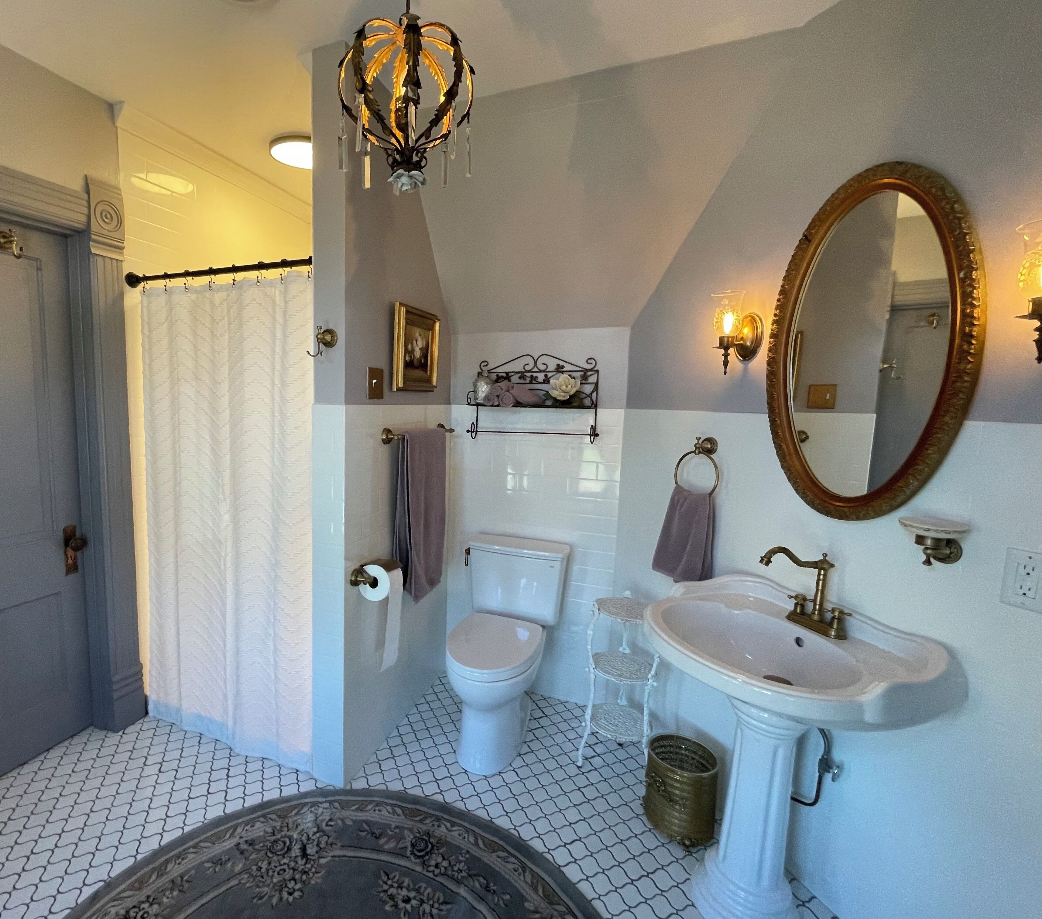 A bathroom with a toilet, sink, and shower curtain.