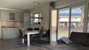 A modern kitchen with white cabinets and a dining area with a table and chairs.