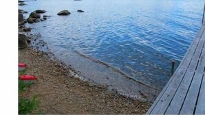 A calm lake with a wooden dock extending into the water.
