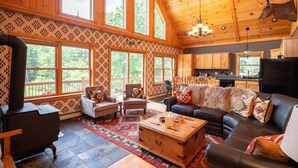 A spacious living room with a fireplace, a large sofa, and a dining area. - The Lone Star- Hot Tub, AC, Pool Table (Newry)