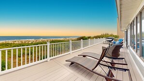 A deck with wicker chairs and a barbecue grill overlooking a beach. - 6 Bedroom Oceanfront House in N. Bethany Beach. Renovated in 2024. Watch video! (Bethany Beach)