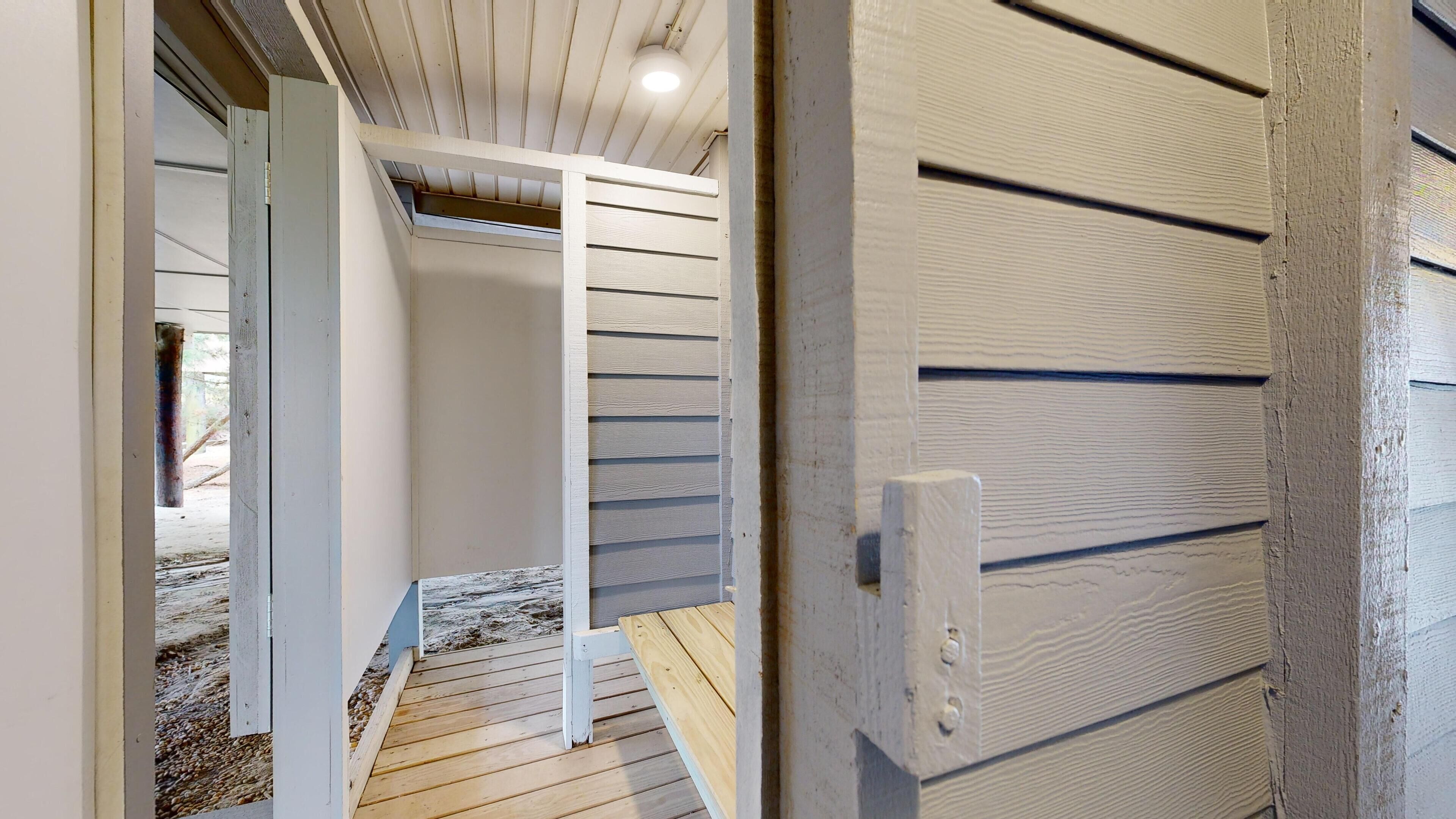 A wooden staircase leading to a lofted area with a sloped ceiling and a door with horizontal paneling.