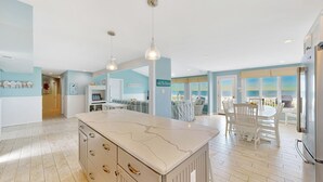 A spacious kitchen with a large island, pendant lighting, and a view to the outside. - 6 Bedroom Oceanfront House in N. Bethany Beach. Renovated in 2024. Watch video! (Bethany Beach)