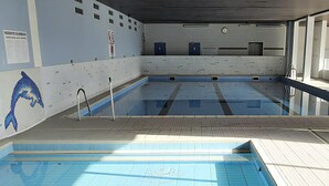 Sisätiloissa sijaitseva uima-allas, jonka seinät ja lattia ovat laatoitettu, ja lattian laatat ovat sinisiä.