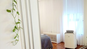A bedroom with a bed, a heater, and a window with curtains. - Temporary Apart. Excellent location in the historic center of Cordoba! One bedroom (Córdoba)