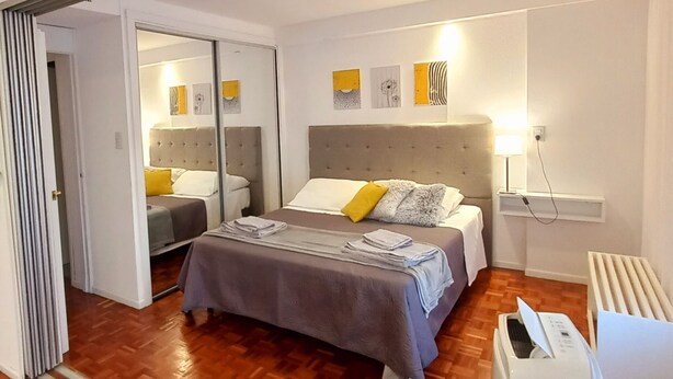A modern bedroom with a large bed, a heater, and a mirror. - Temporary Apart. Excellent location in the historic center of Cordoba! One bedroom (Córdoba)