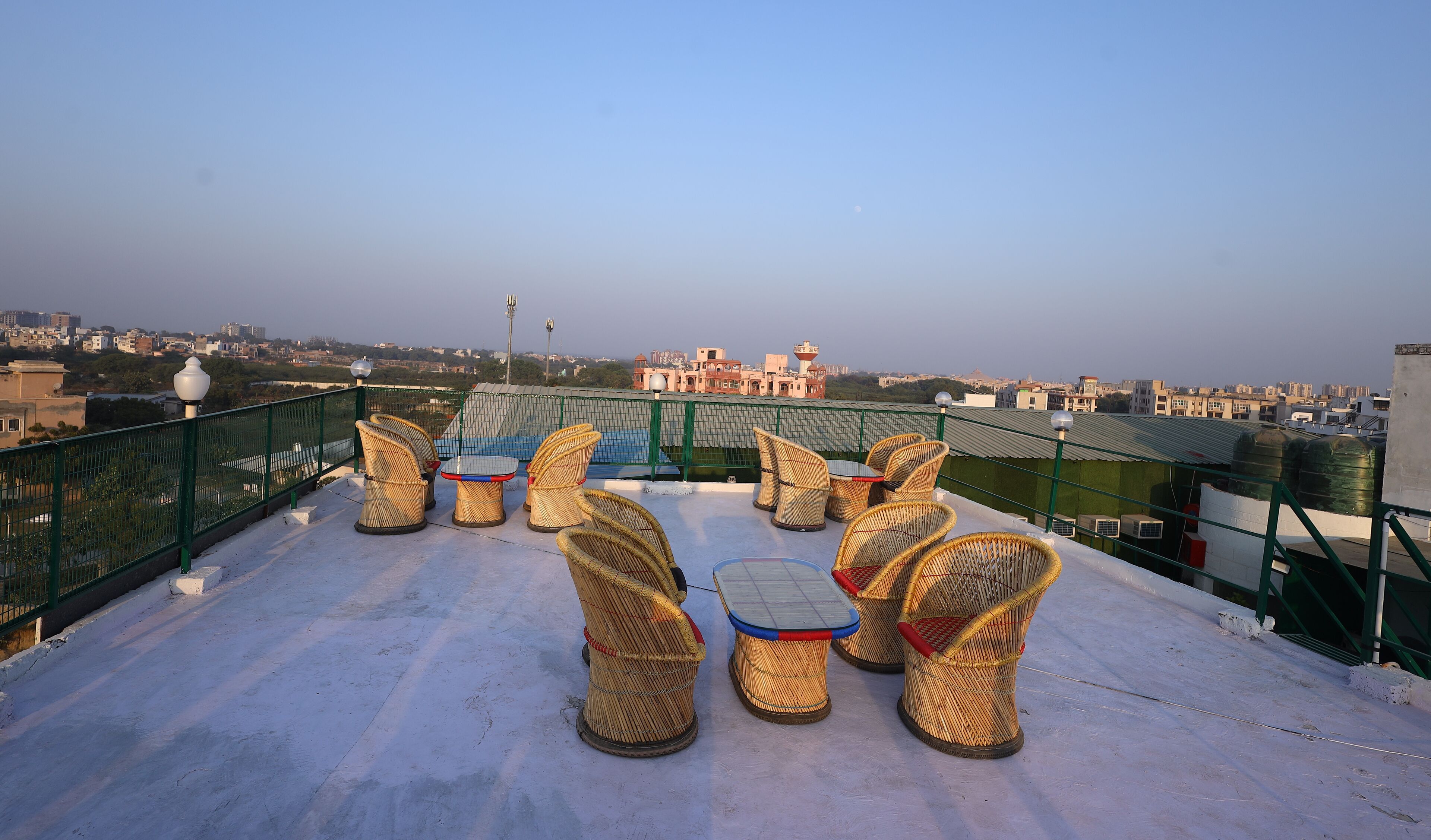 A rooftop terrace with wicker furniture and a view of the cityscape.