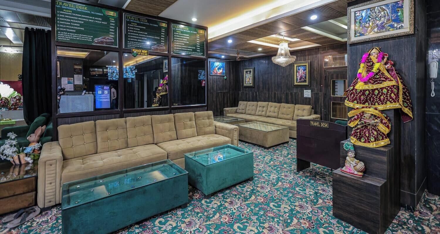 A travel desk with a menu, a sofa, a glass coffee table, and a decorative statue.