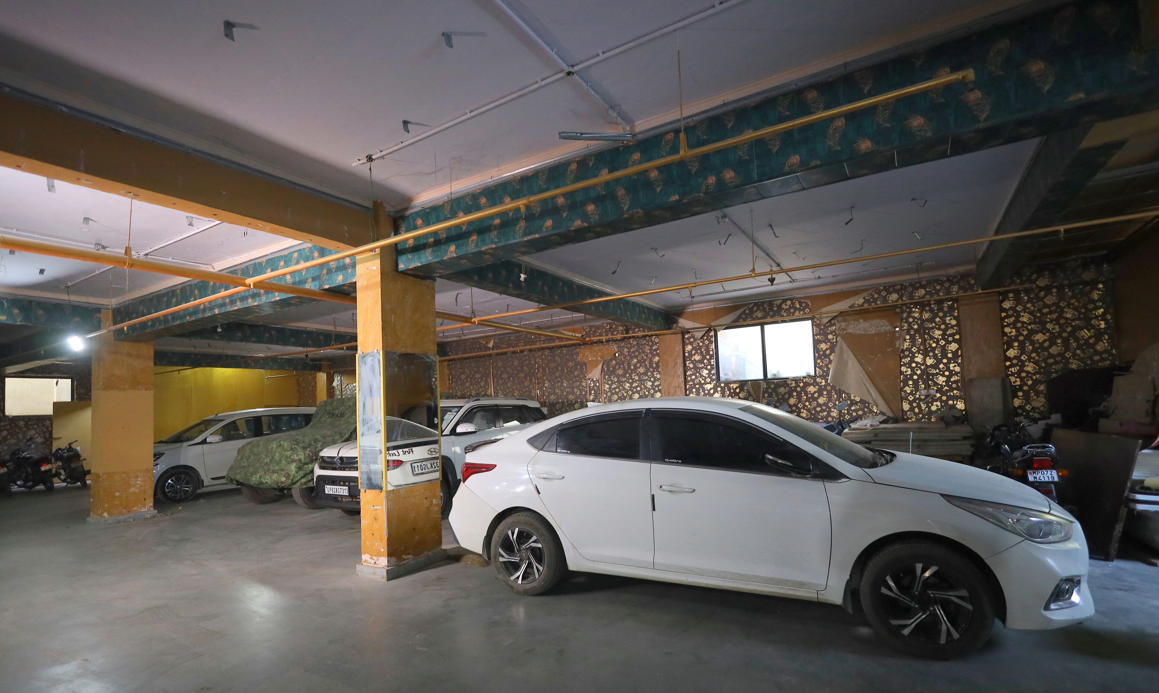 Un estacionamiento de varios niveles con suelo de hormigón y vigas metálicas.