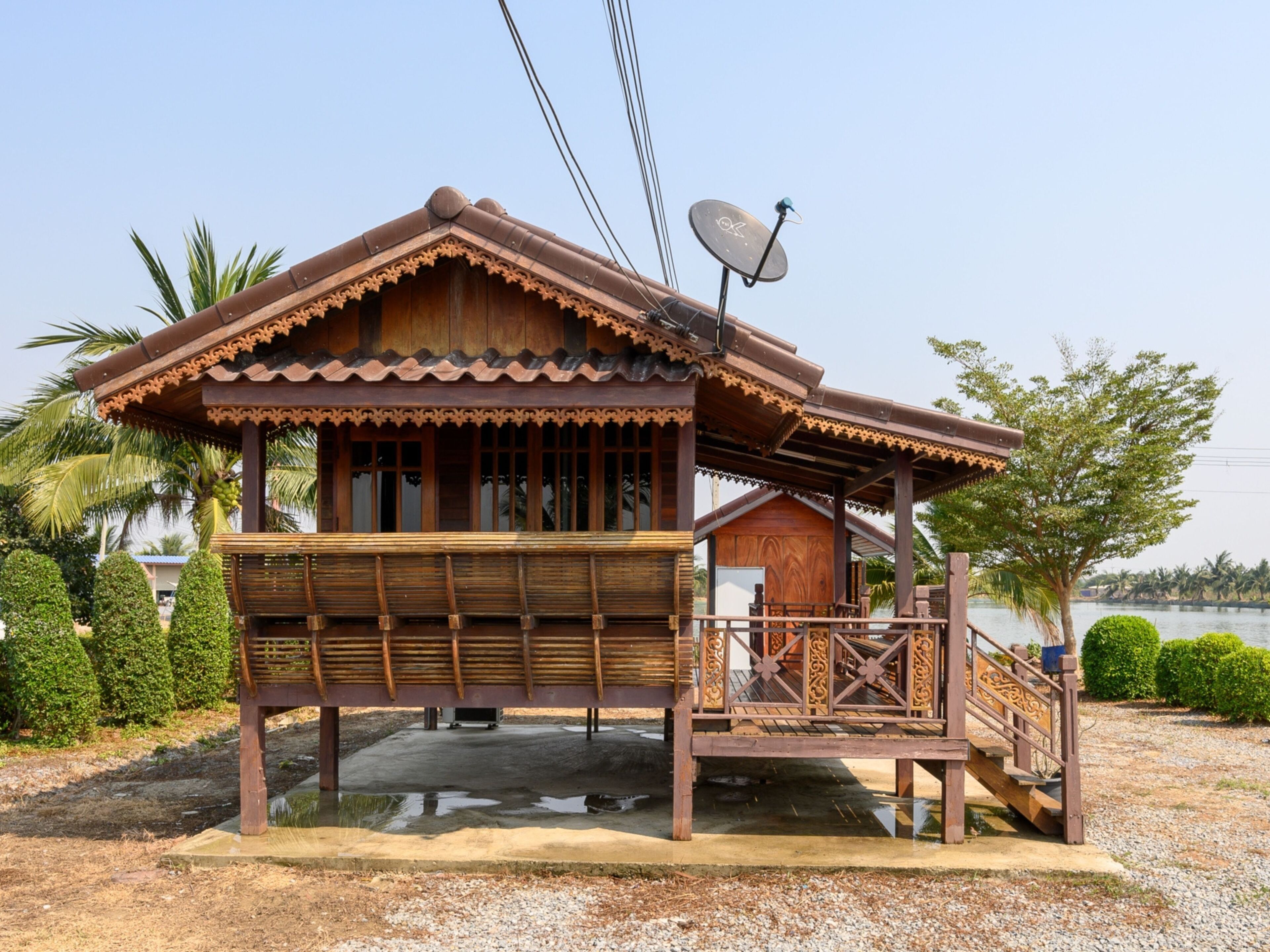 A wooden house with a balcony, a satellite dish, and a view of a lake.