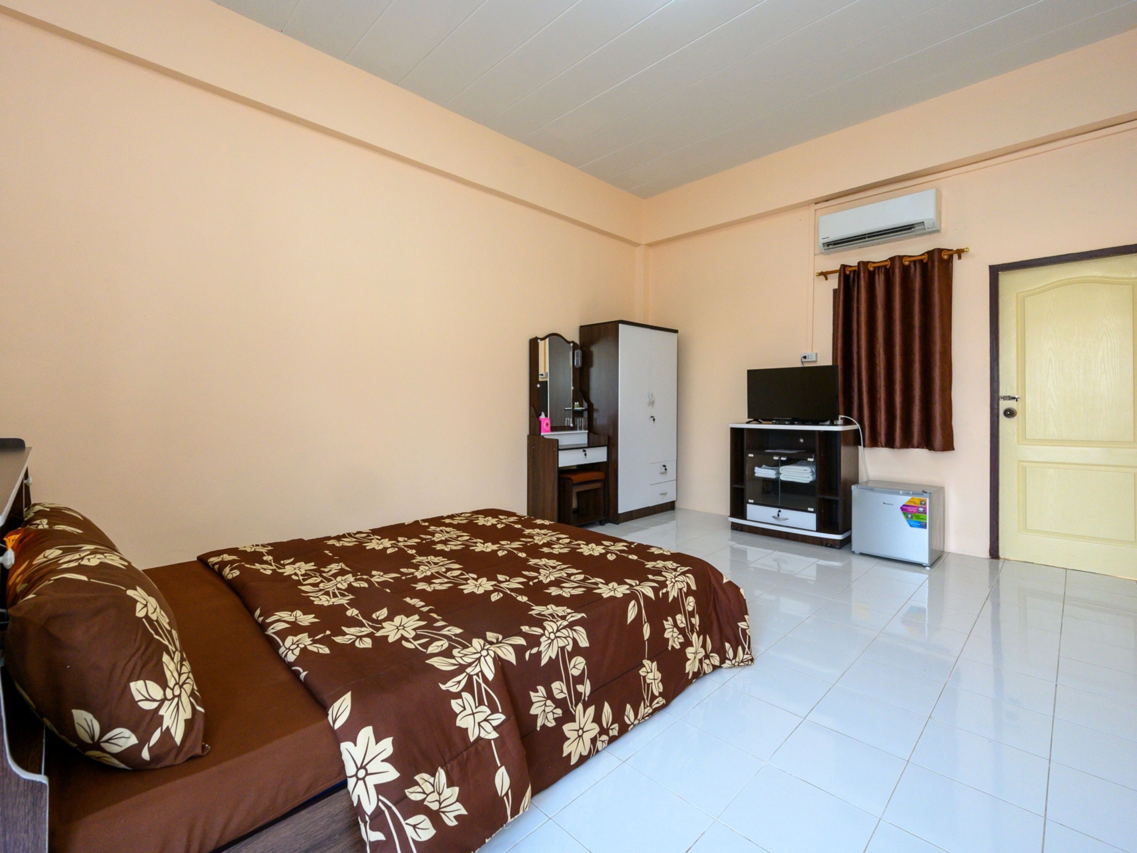 Una habitación de hotel con cama, armario, televisión y aire acondicionado.
