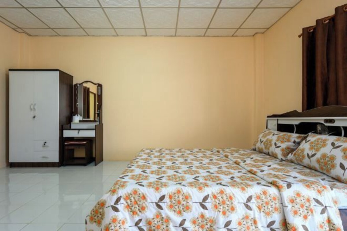 Un dormitorio con cama, armario, escritorio y espejo.
