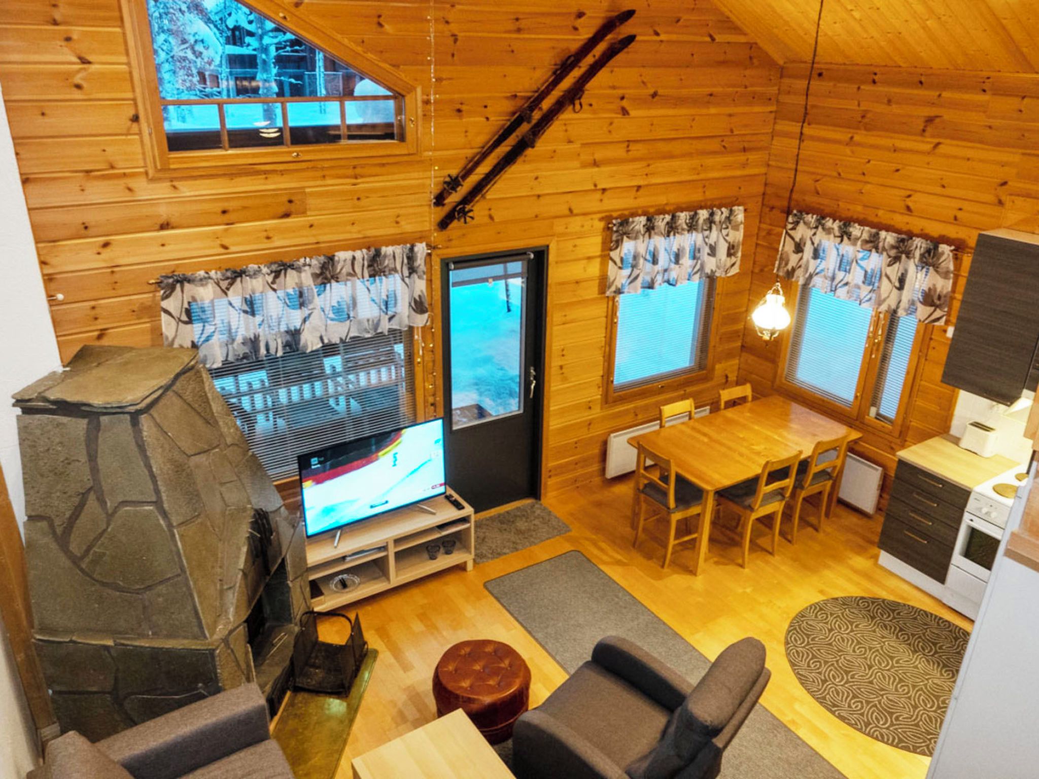 Un acogedor interior de cabaña con chimenea, comedor y televisor.
