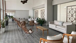 Un vestíbulo espacioso con techo alto, muebles modernos y elementos decorativos.