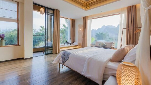 Una camera da letto con un grande letto, un balcone con vista e un pavimento in legno.