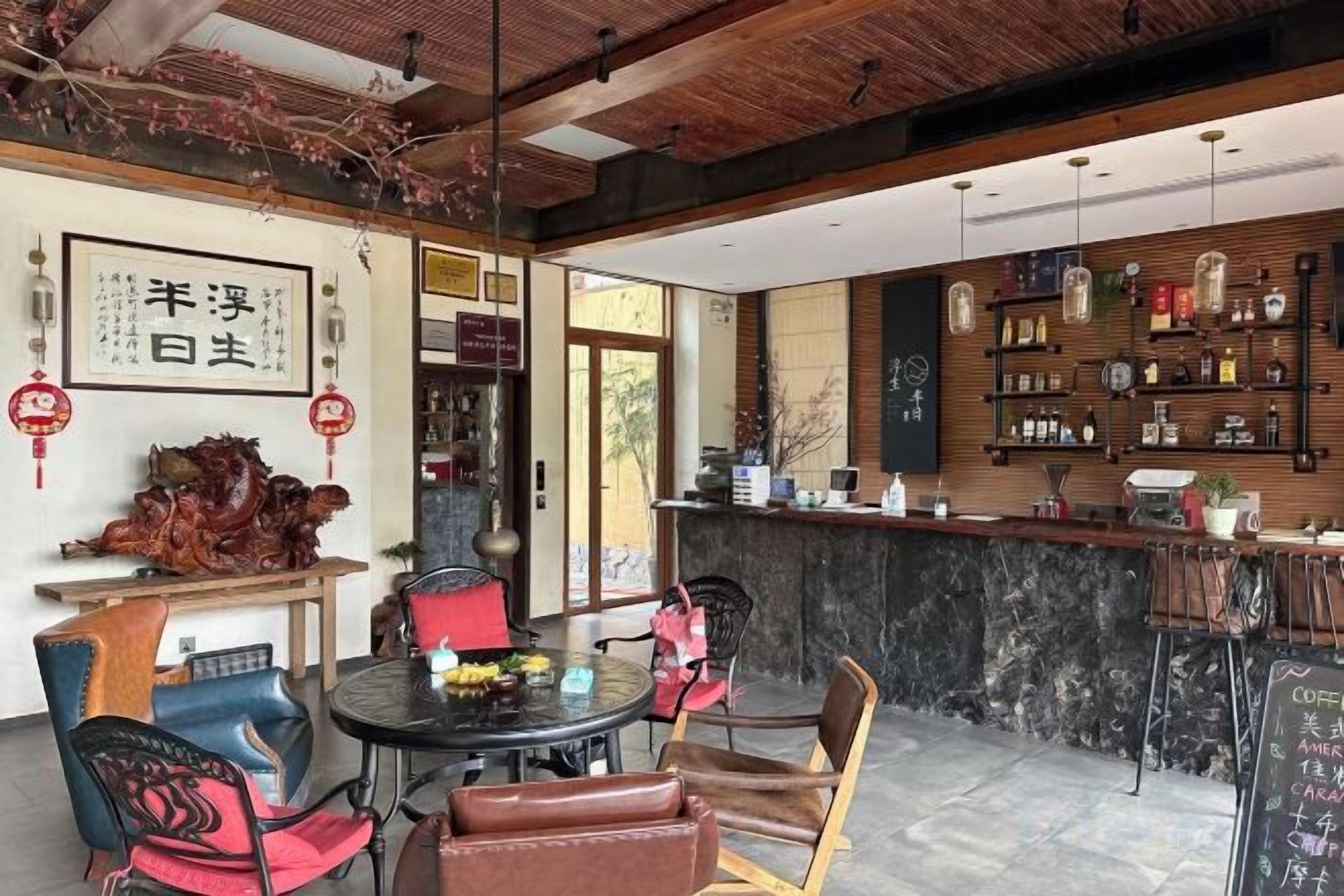 A restaurant with a bar area, seating, and a decorative wall with calligraphy.