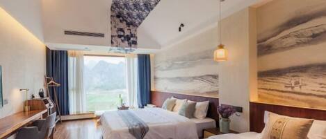 Habitación de hotel con dos camas, un escritorio, una silla y un amplio ventanal con cortinas.