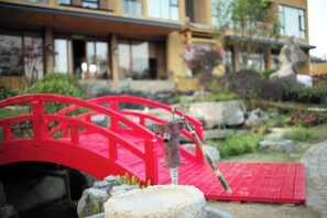 A red bridge with a water feature, a stone platform, and a building with large windows in the background. - Fusheng Banri Guesthouse (Guilin Zhujiang) (Guilin)