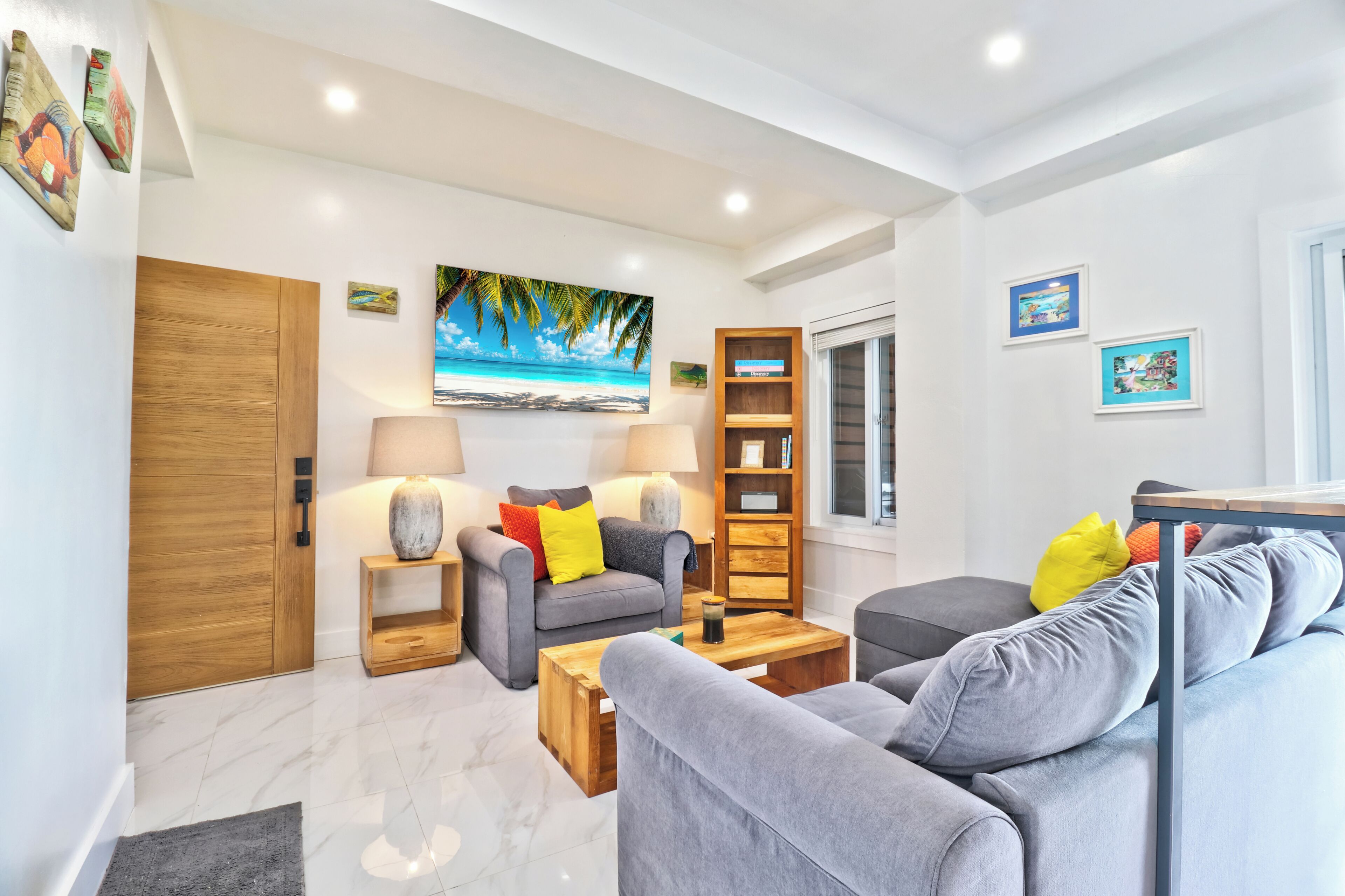 A modern living room with a sofa, coffee table, and a bookshelf.