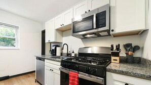 A modern kitchen with white cabinets, a stainless steel stove, a microwave, and a coffee maker. - ★ HostWise Stays ★ Pet Friendly, Butler St. Apt with Private Entrance (Pittsburgh)