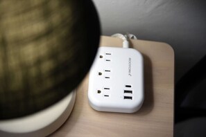 A white power strip with multiple outlets and USB ports on a wooden surface. - Butler St Cozy Retreat, Walk to Breweries & Shops (Pittsburgh)
