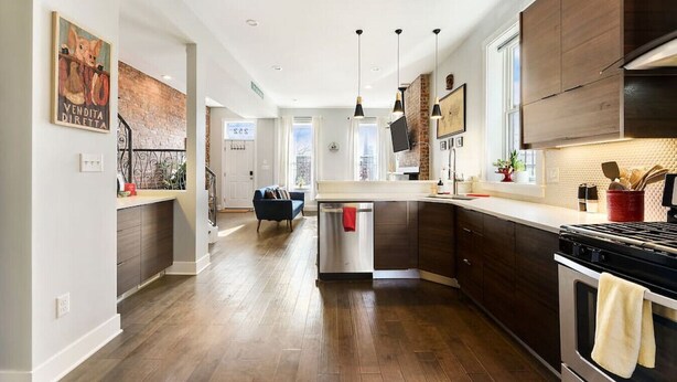 A modern kitchen with dark wood cabinets, a central island, and pendant lighting. - ★ HostWise Stays ★ Family Friendly, Great Area, Artist Abode! (Pittsburgh)