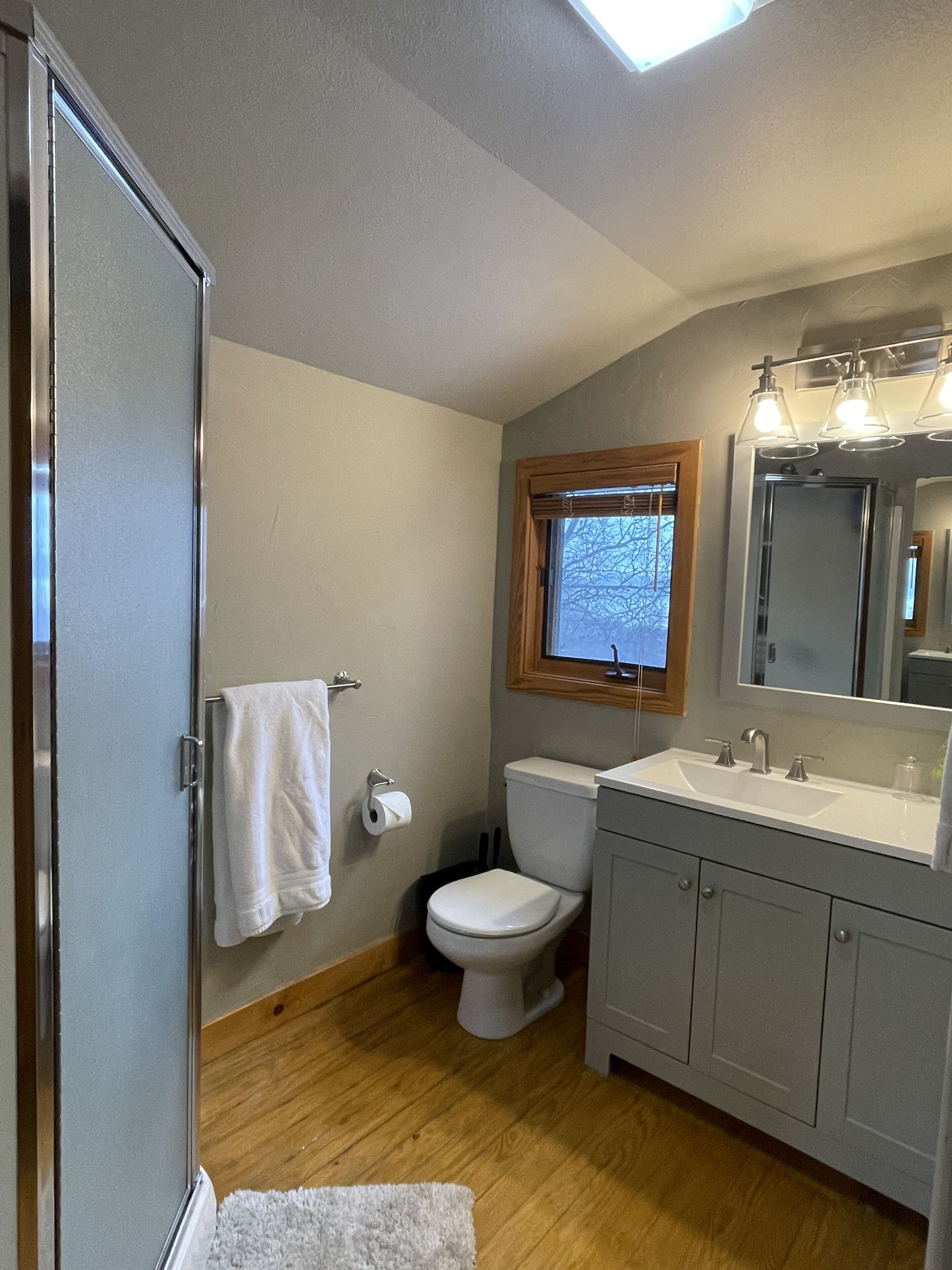A bathroom with a toilet, sink, and mirror.