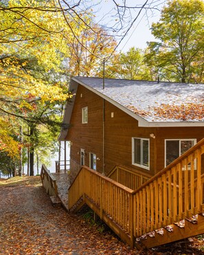A cabin with a wooden deck and a staircase leading to the entrance. - Modern cottage escape in Muskoka (Huntsville)