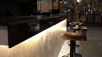 Una zona de bar con mostrador y taburetes.