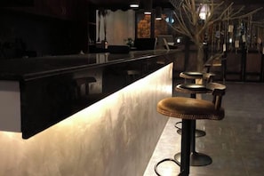Uma área de bar com balcão e banquetas.