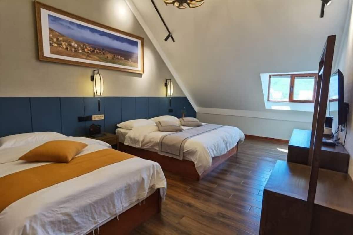 Un dormitorio con dos camas, un cuadro grande y una ventana.