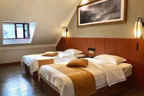 Habitación de hotel con dos camas, un tragaluz, un cuadro y una mesita de noche.