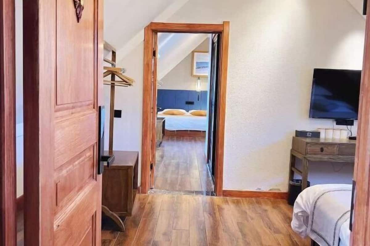 Un dormitorio con cama, mesita de noche, televisor y armario.