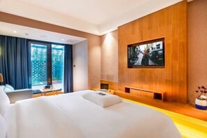 A modern hotel room with a large bed, a TV mounted on the wall, and a view of the outdoors through the window. - HAI FU JING (Guiyang)