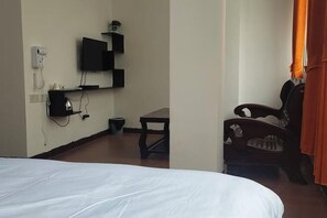 A hotel room with a bed, a desk, a chair, a television, and a telephone. - Phoenix Hotel, Wuzhou (Wuzhou)