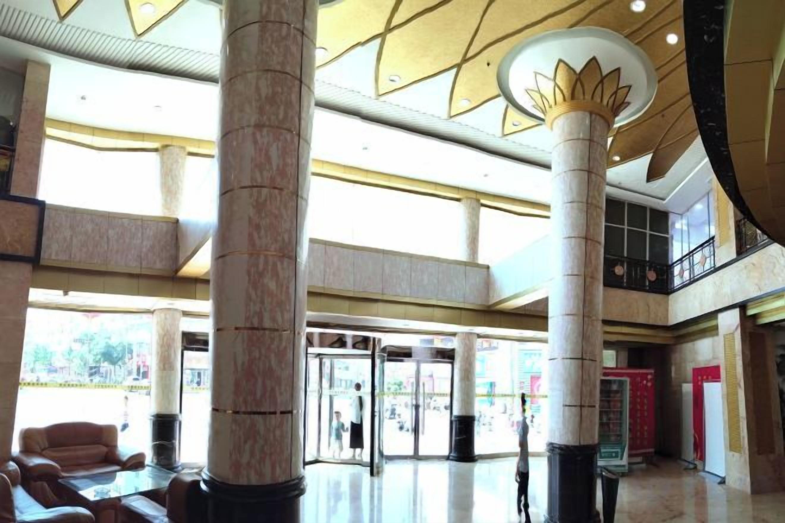 A spacious lobby with high ceilings, large columns, and a modern design.