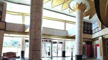 A spacious lobby with high ceilings, large columns, and a modern design.