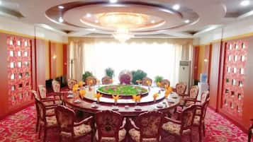 A conference room with a round table, chairs, and a chandelier.