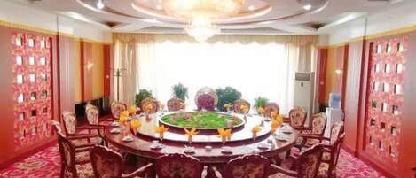 A conference room with a round table, chairs, and a chandelier.