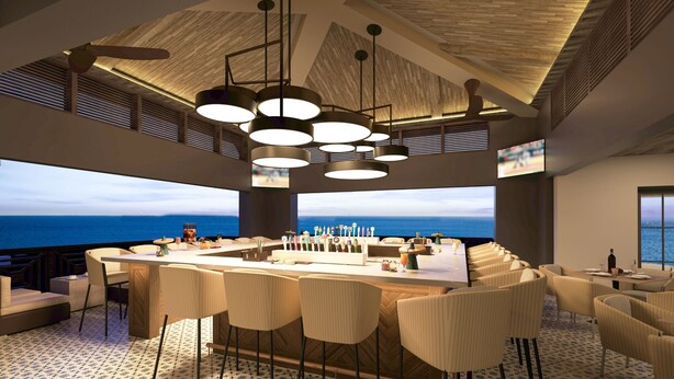 A modern bar area with a central island, multiple hanging lights, and a view of the ocean. - Hotel Indigo Panama City Marina by IHG (Panama City)