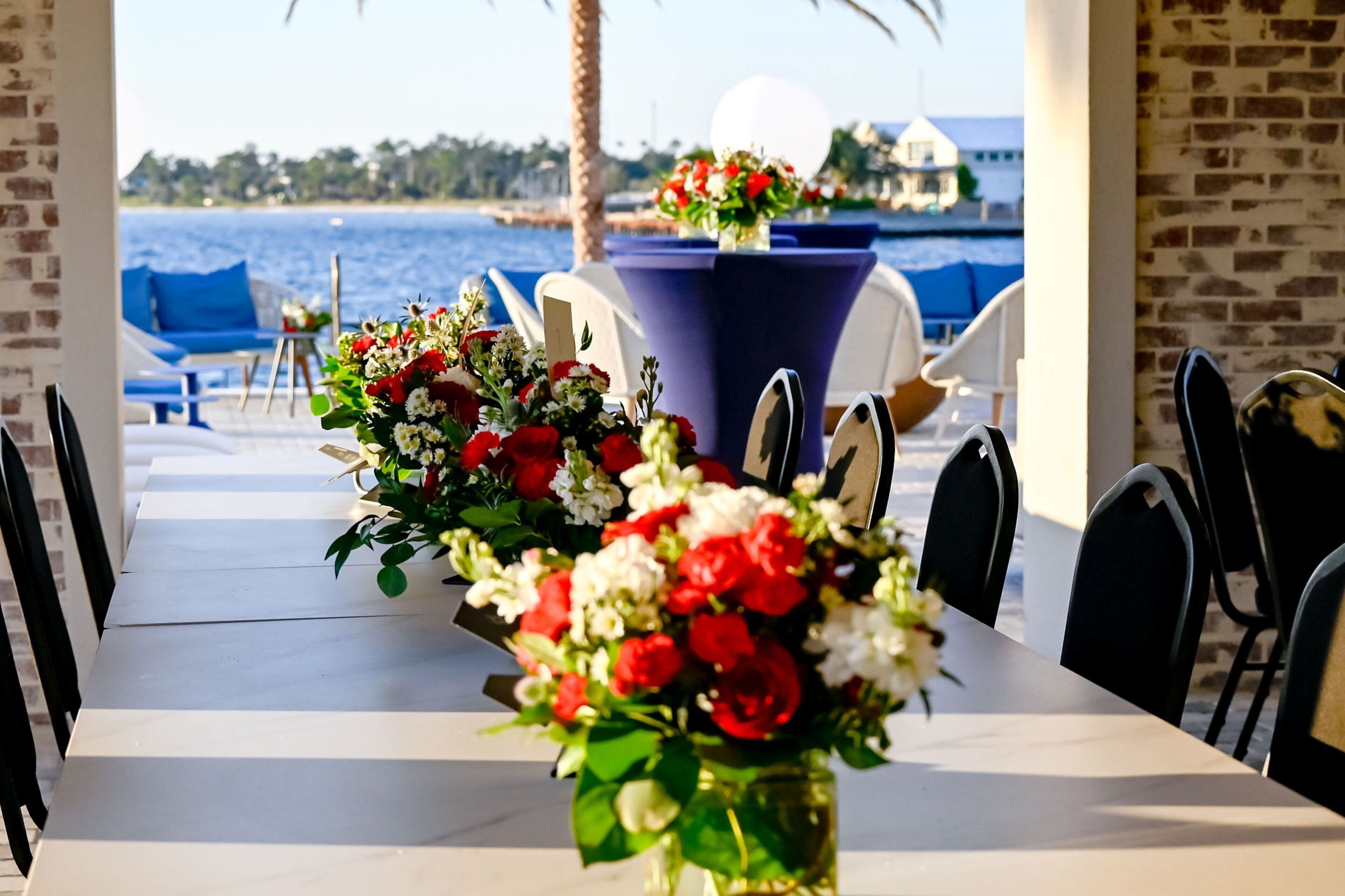 A dining table with chairs and a view of the sea.