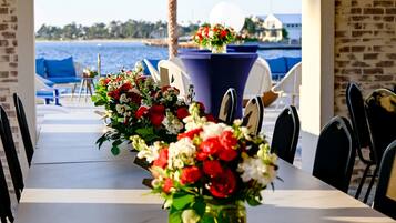 A dining table with chairs and a view of the sea.
