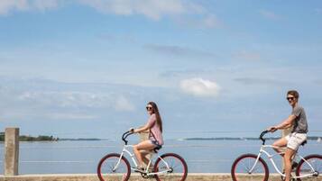 Twee personen fietsen langs een waterkant.