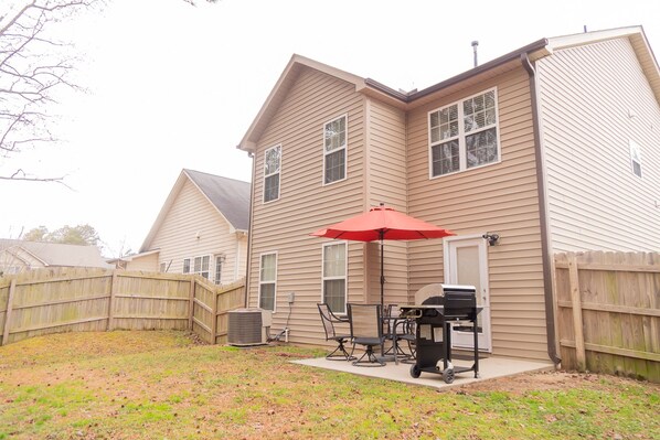 A house with a backyard patio featuring a grill and outdoor furniture. - Beautiful home away from home (Raleigh)