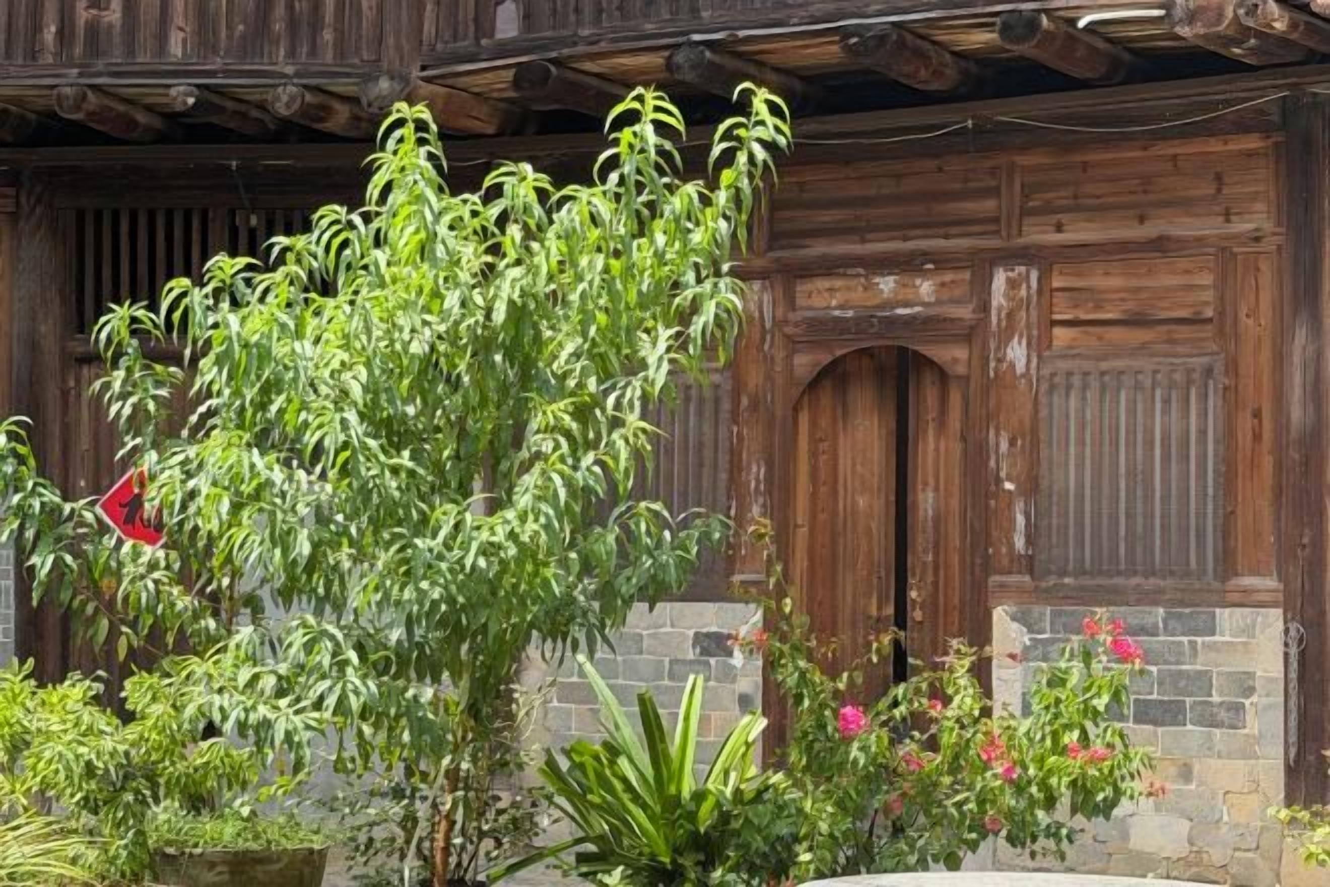 Un edificio rústico con puertas de madera y una pared de piedra.