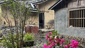 A traditional building with a stone foundation, a brick wall, and a window with metal bars.