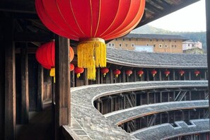 A traditional building with curved wooden architecture and red lanterns. - Yuqinglou Inn (Longyan)