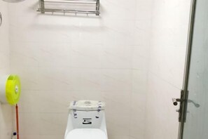 A bathroom with a toilet, a yellow hand dryer, and a towel rack. - Yuqinglou Inn (Longyan)