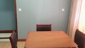 A room with a wooden table and two chairs, light blue walls, and a window with curtains. - Shuangfeng Century Hotel (Shuangfeng)