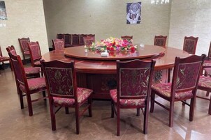 Una mesa redonda de madera rodeada por ocho sillas con centros de mesa florales.